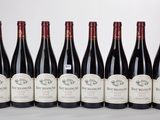six bouteilles de vin sont alignées sur une table