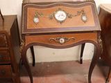 a small table with a clock on it next to a chair