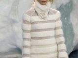 the woman is wearing a white and gray sweater and skirt