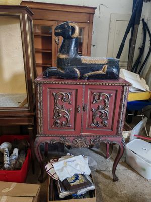 une armoire rouge surmontée d'une statuette de chien noir