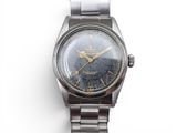 a close up of a wrist watch on a white surface
