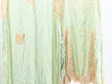 two green dresses hanging on a clothes rack in a room