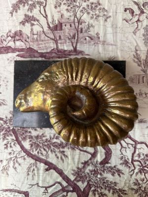 a gold shell shaped object on a purple and white wallpaper