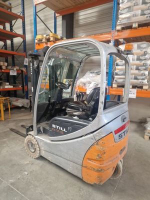 a forklift in a warehouse with pallets in the background