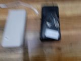 une photo floue montrant un téléphone portable et un chargeur posés sur une table