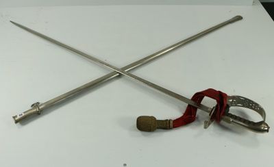 deux épées et une pince posées sur une table blanche