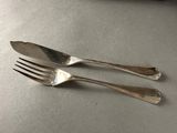 pair of silver plated forks on a table with a knife and fork