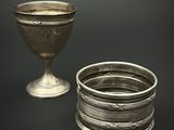 une coupe en argent posée à côté d'une autre coupe en argent sur une table