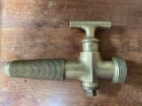 an old brass faucet on a wooden table