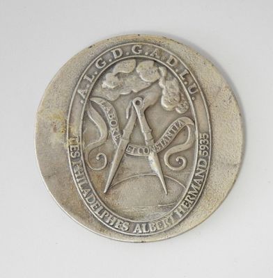une pièce d'argent sur laquelle figure un symbole maçonnique