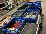 Des cartons contenant des articles variés sont alignés sur un chariot dans un entrepôt.