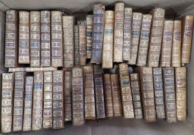 une boîte pleine de vieux livres posée sur le sol