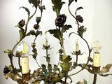 un lustre duquel pendent des bougies et des fleurs