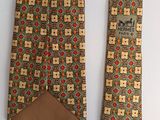 two neck ties with different designs on them on a white surface