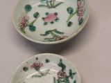 two bowls with flowers on them sitting on a table