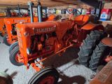 an orange tractor that is parked in a garage