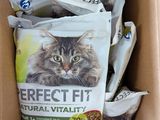 une boîte remplie de nourriture pour chat, avec un chat assis dedans