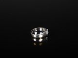a close up of a silver ring on a black surface