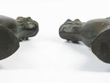 two bronze sculptures of a man and a woman on a white surface