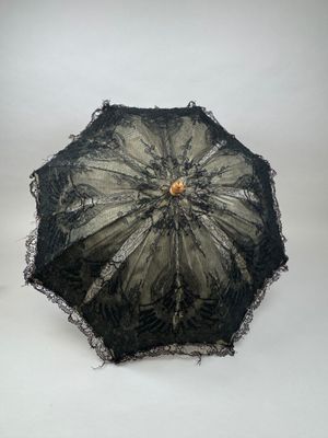 un parapluie en dentelle noire avec un manche en bois sur fond blanc