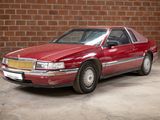 a red car that is parked in front of a brick wall