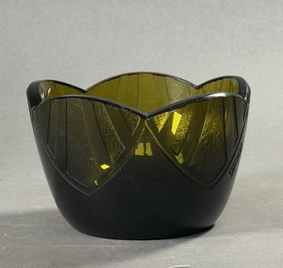 un bol en verre vert posé sur une table à côté d'une paire de ciseaux