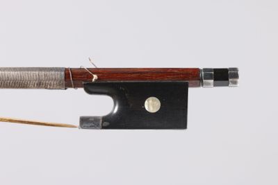 un gros plan d'un archet de violon auquel est attaché un morceau de corde