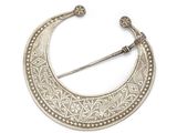a silver crescent shaped broochle with intricate design