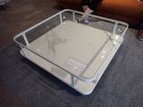 une table basse avec un plateau en verre posée sur un sol recouvert de moquette