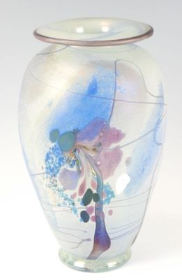 un vase en verre avec un tableau posé sur une table