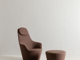 une photo représentant une chaise et un pouf dans une pièce blanche
