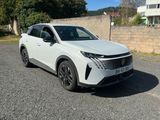 un SUV blanc garé sur un parking à côté d'un immeuble