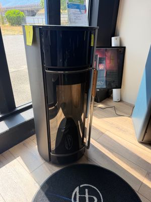 une cafetière posée par terre devant une fenêtre
