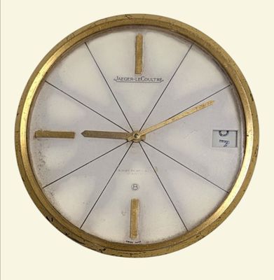 une horloge dorée avec un cadran blanc sur fond blanc