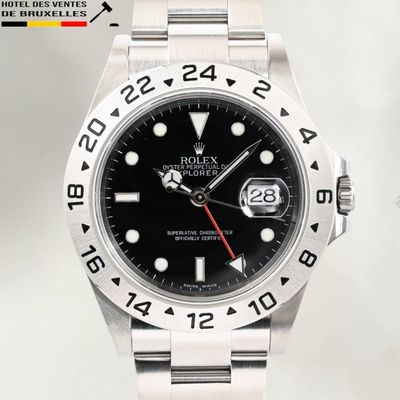 the rolex watch has black dials and a red second hand