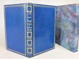 un livre bleu ouvert, bordé d'or, avec une illustration sur la couverture