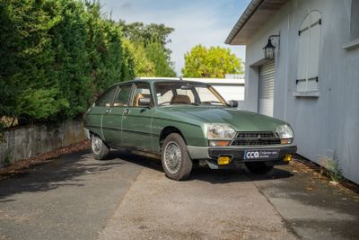 une voiture verte garée devant un immeuble