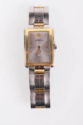 une image d'un gros plan d'une montre-bracelet sur une surface blanche