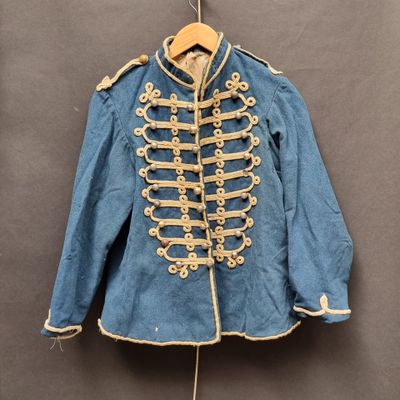 une vieille veste militaire bleue suspendue à un cintre accroché au mur