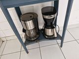 deux cafetières posées sur une petite table bleue
