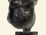 statue of a woman with a large breast sitting on a square base