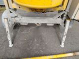 a yellow cement mixer sitting on the ground