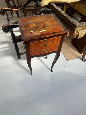 a small table with a drawer on it in the middle of a room