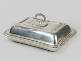 an antique silver plate covered with a handle and a ring on top