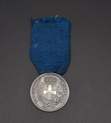an old medal with a cross on it sitting on a table