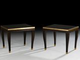 two black and gold side tables on a white surface