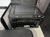a black stove with a glass top and a trash can underneath it