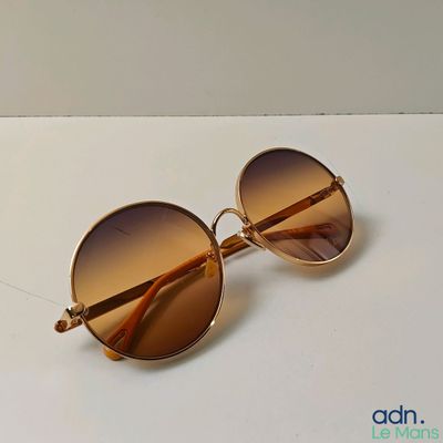 sunglasses on a table with a white surface and a white background