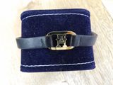 black leather bracelet with a gold buckle on a blue velvet case