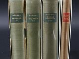 three books are stacked on top of each other on a black surface